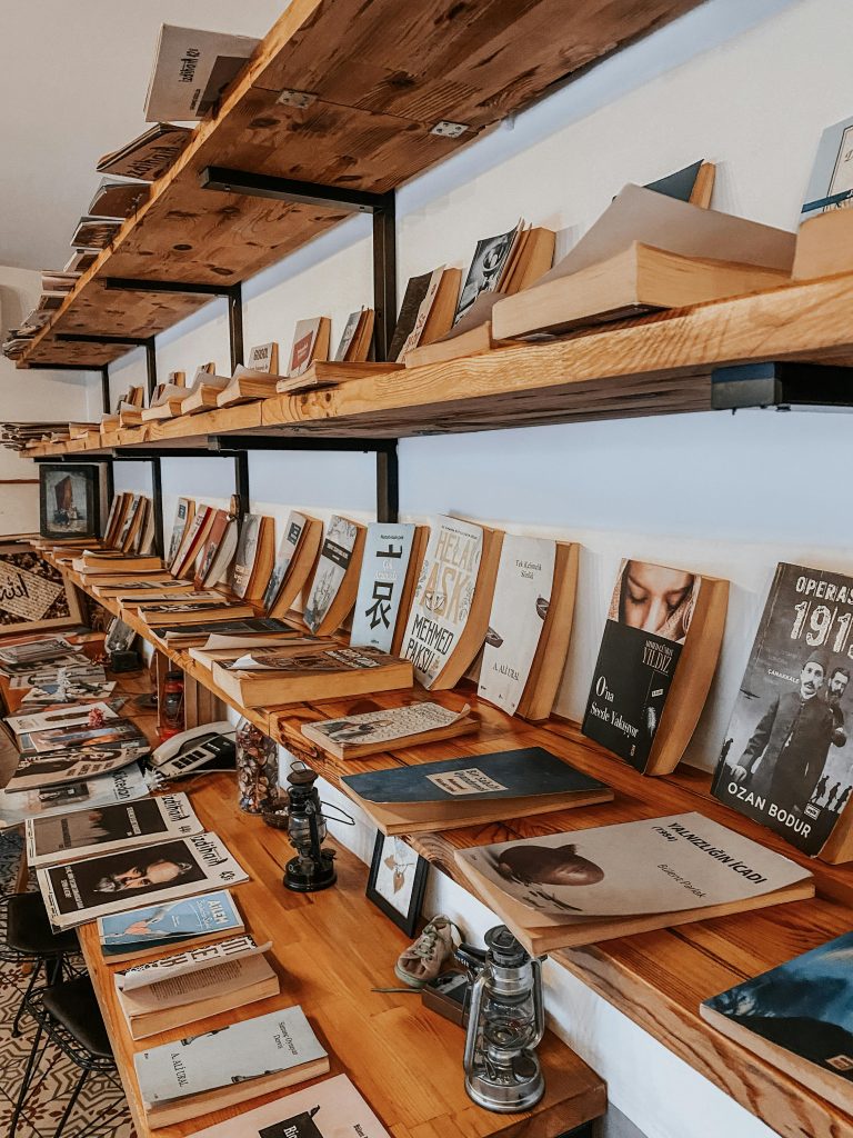 A rustic wooden bookshelf filled with a diverse collection of vintage and modern books.