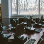 Spacious computer lab with rows of monitors and keyboards in a sunlit room.