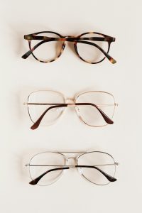 Stylish diverse glasses arranged in row lying down glasses on beige table